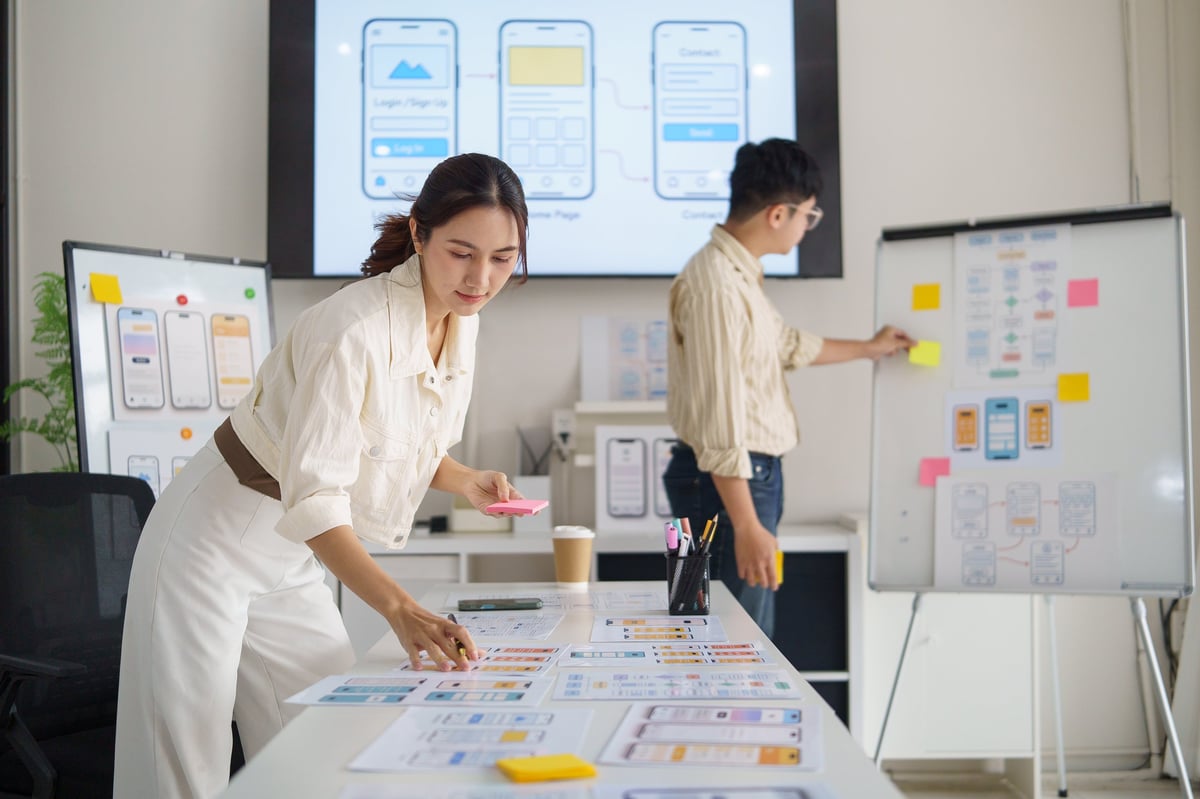 UX designer planning mobile app interface with sticky notes and planning materials